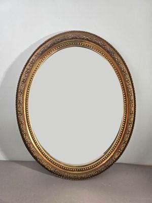 un gros plan d'un miroir posé sur une table près d'un mur