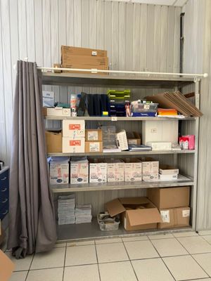 many boxes and boxes on a shelf in a storage room