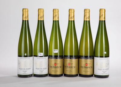 six bottles of wine are lined up in a row on a white surface