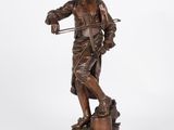 a bronze statue of a man with a cane and hat