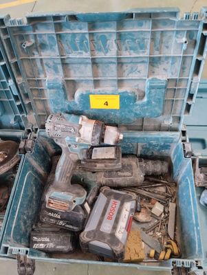 une boîte à outils bleue contenant des outils, posée par terre