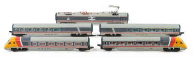 four model trains are lined up on a white surface