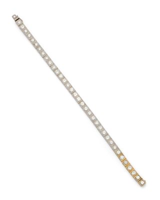 un gros plan d'un bracelet en argent et en or sur fond blanc