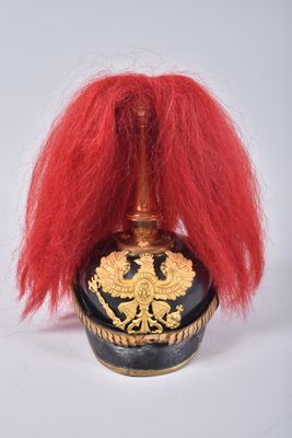 a red wig sitting on top of a black and gold vase