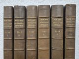 five old books sitting on top of a wooden table