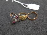 two gold rings with red stones and a tag on a black surface