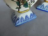 two vases with flowers on them on a table