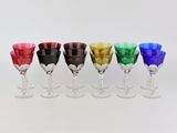 six verres à vin de couleurs différentes sont alignés