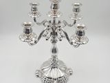 a silver plated candelab with five candles on a stand