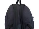 black backpack with black straps hanging on a white wall