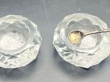 two clear glass bowls with spoons on a table