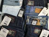 several pairs of men ' s jeans are stacked on top of each other