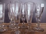 several empty wine glasses are lined up on a wooden table