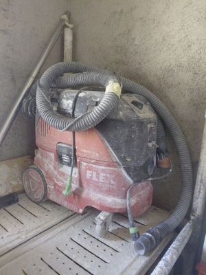 a red duster sitting on the floor next to a pipe