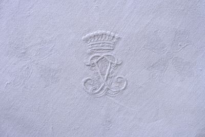 un gros plan sur une serviette blanche ornée d'une couronne