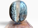 une photo d'une bille bleue et blanche posée sur un socle transparent