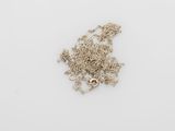 a close up of a bunch of silver chains on a white surface