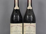 deux bouteilles de vin rouge sont posées sur une table en verre