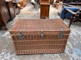a wicker trunk sitting on the floor in a warehouse