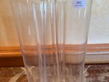 trois vases en verre transparent posés sur une table en marbre