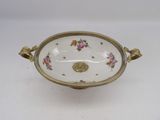 a white bowl with flowers on it sitting on a table