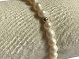 bracelet de perles posé sur une serviette, muni d'un fermoir à perle dorée