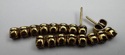 a close up of a bunch of gold colored beads on a white surface