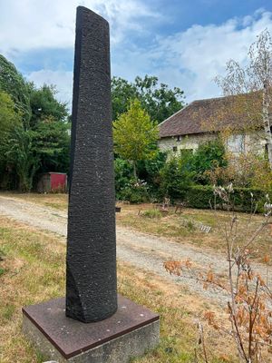 a tall stone obelisk in the middle of a field