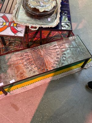 une table en verre sur laquelle est posé un gâteau, avec une personne debout à côté