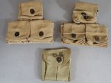 four tan canvas pouchs with buttons on them sitting on a table