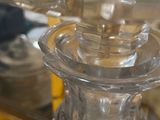 a glass candle holder sitting on a table in front of a mirror