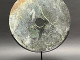 an image of a stone disc on a metal stand