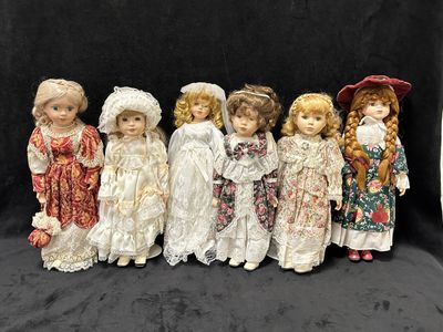 six poupées en porcelaine sont alignées sur un fond noir