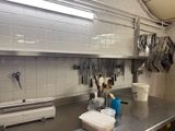 un plan de travail de cuisine avec tout un tas d'ustensiles accrochés au mur