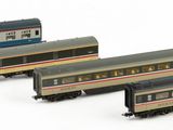 four model trains are lined up in a row on a white surface