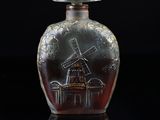 an image of a glass bottle with a windmill design on it