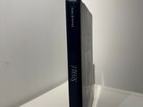 a book sitting on top of a white shelf next to a white wall