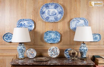 de nombreuses assiettes et lampes bleues et blanches posées sur une table