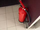 a red fire extinguisher in the corner of a room