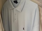the polo shirt is hanging on a hanger in the closet