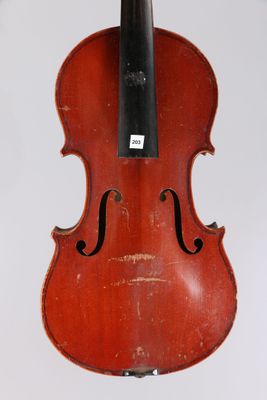an old violin hanging from a string on a white wall