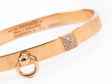 a close up of a gold bracelet with a diamond clasp