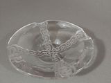 a clear glass ashtray with a decorative design on it