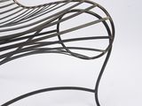 a metal chair that is sitting on a white surface