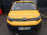 une camionnette Citroën jaune garée sur un parking devant un immeuble