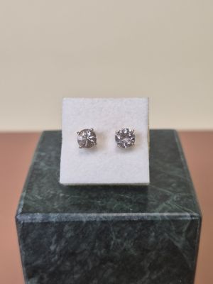 a pair of earrings sitting on top of a marble block