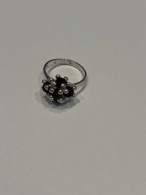 gros plan d'une bague en argent sur une surface blanche