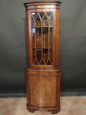 a wooden corner cabinet with glass doors and a glass door