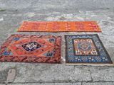 trois tapis étalés par terre sur un parking
