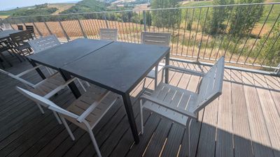 une table et des chaises sur un balcon avec vue sur les montagnes